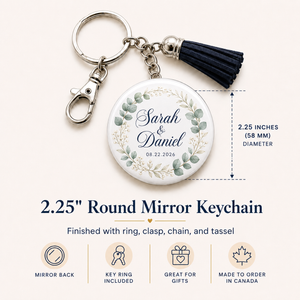 Personalized round mirror keychain with a silver clasp and chain, a black tassel, and a white face printed with a floral wreath and the names Sarah & Daniel plus the date 08.22.