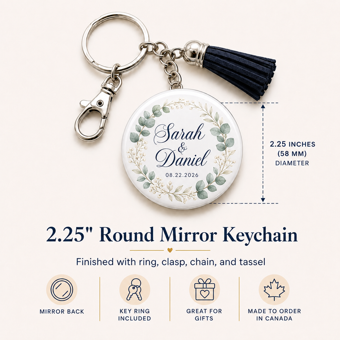 Personalized round mirror keychain with a silver clasp and chain, a black tassel, and a white face printed with a floral wreath and the names Sarah & Daniel plus the date 08.22.