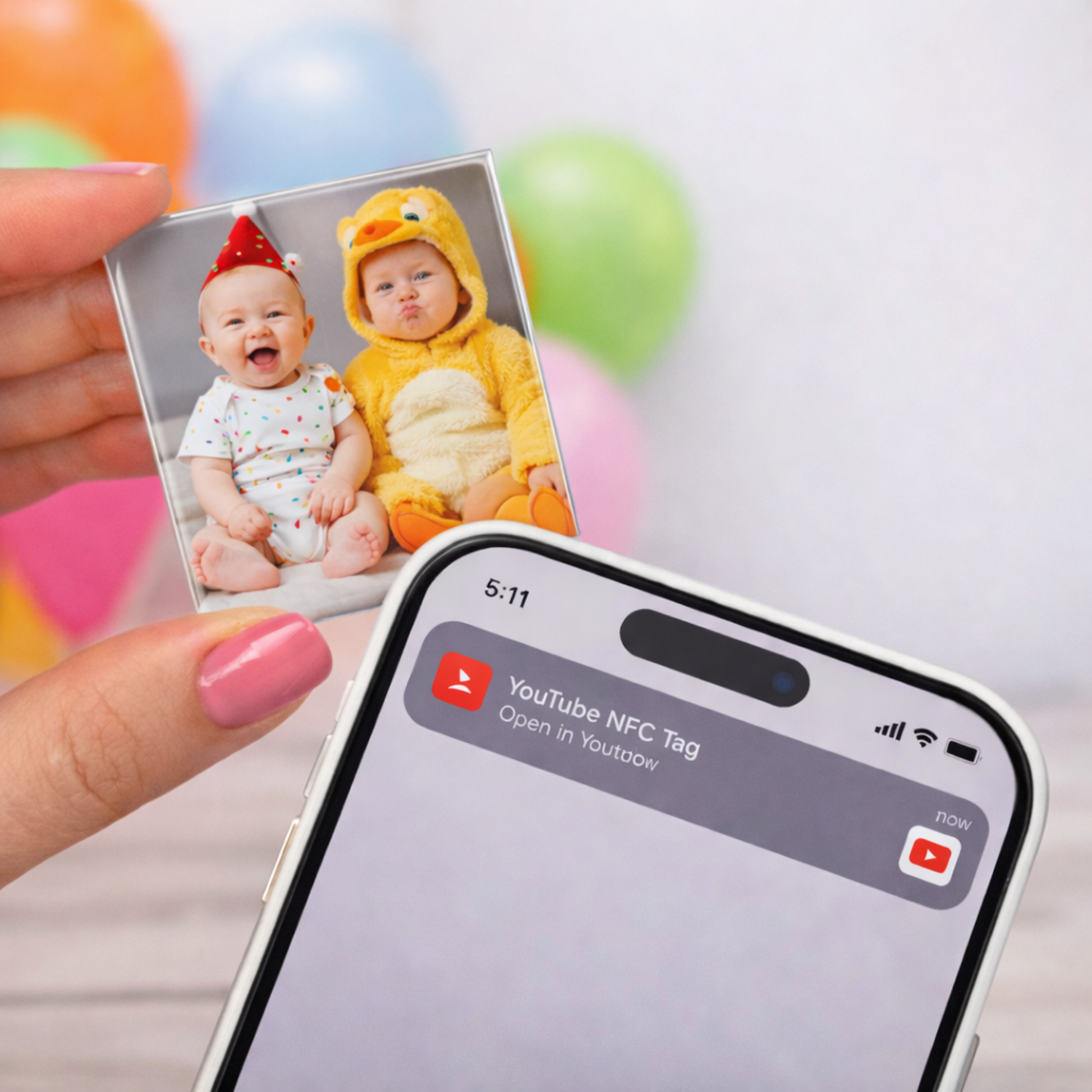 Hand holding a photo of two children next to a smartphone with a YouTube app notification.
